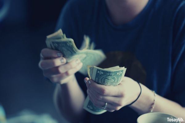 woman wearing blue shirt counting money