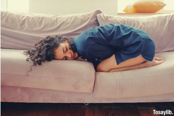 woman lying on the sofa blue clothes and curly hair