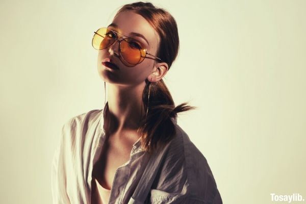 woman standing indoor long hair yellow sunglasses