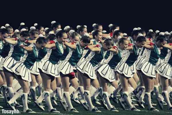 action cheerleaders cheerdance green white uniform field