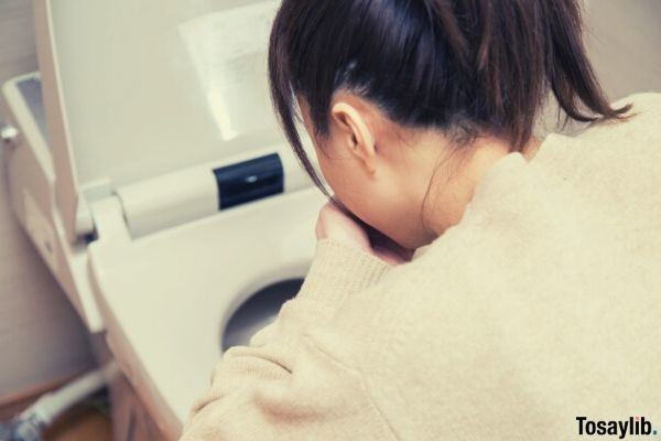 woman vomiting in the toilet