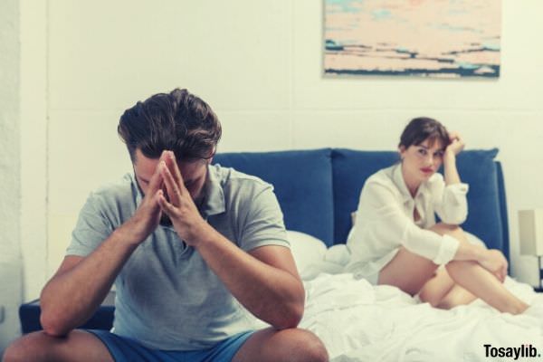 photo of man and a woman sitting on top of bed having some bad situation