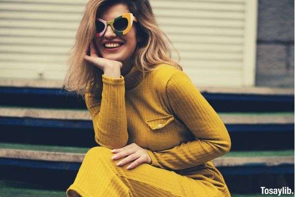women s yellow long sleeved dress sitting on the staircase