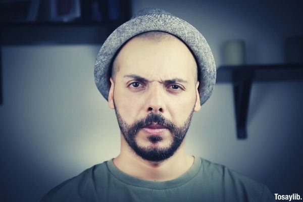 Photo of a man angry wearing gray cap and crew neck tshirt