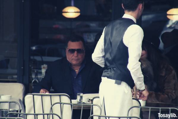 man wearing black suit jacket and sunglasses on the restaurant