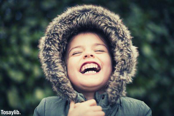 selective photography of a child wearing mink coat laughing