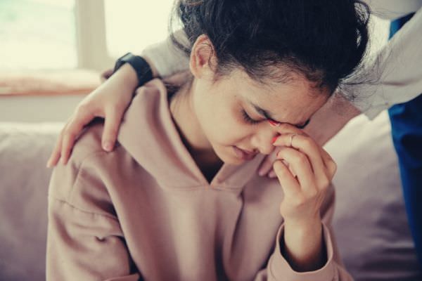 therapist comforting patient wearing pastel peach jacket