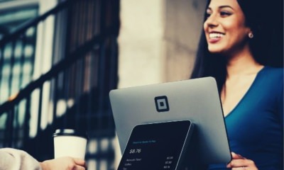 woman-in-blue-smiling-in-front-of-gray-computer-monitor