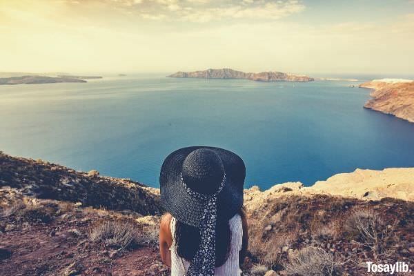 woman in black hat looking at the lake