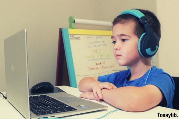 online learning boy wearing headset looking at the laptop