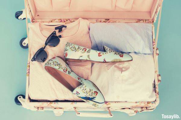 pink clothing items pair of shoes inside luggage