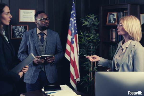 lawyers standing and talking to each other inside the office american flag