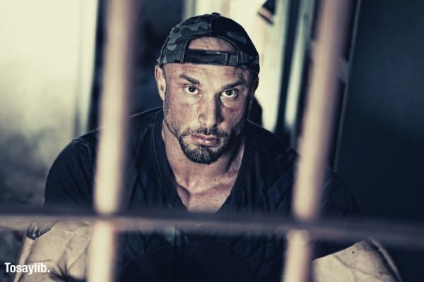 man in black shirt wearing cap inside the jail
