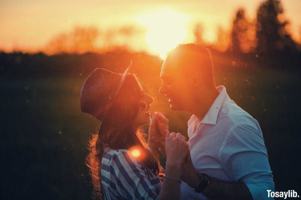 man in long sleeves and woman wearing stripes happy during golden hour