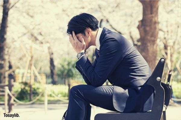 man suit sobbing bench trees