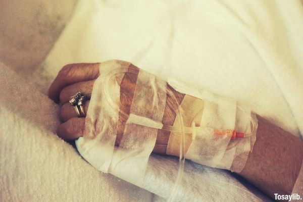 person sick lying on bed wearing dextrose and gold ring