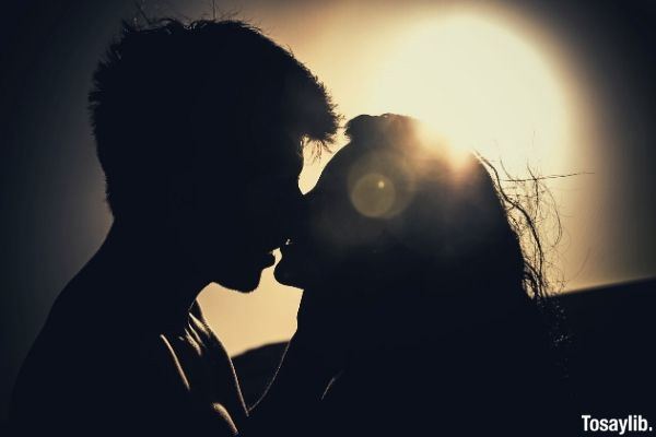 silhouettes of couple kissing in the sunset