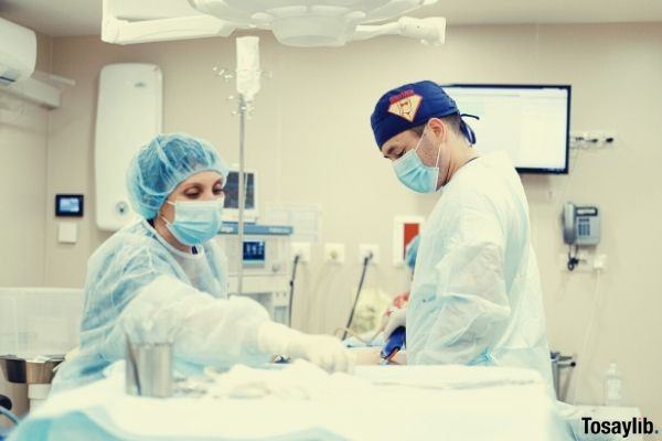 photo of two healthcare professionals inside operating room ultrasound wearing scrubsuits