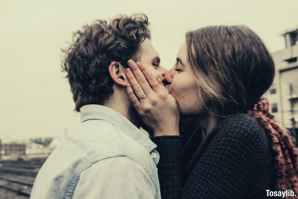 couple kissing under gray clouds