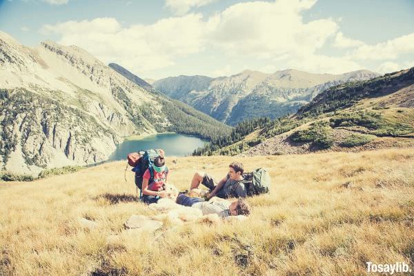 hikers relax on a mountainside meadow in colorado friends lying