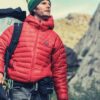 man-hiking-looking-somewhere-holding-his-shoes-backpack-red-jacket