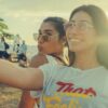 feature-two-women-friends-wearing-sunglasses-taking-a-selfie-of-theirselves-and-sunset