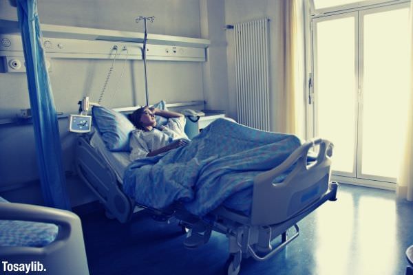 woman lying in hospital bed sick getting well