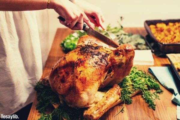 woman is about to slice a turkey wooden cutting board