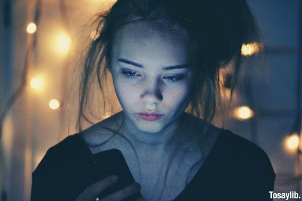 night time girl using smartphone bokeh lights background