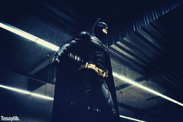 batman standing under a steel roof straight white lights