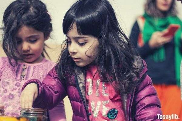 girl in pink shirt with purple jacket playing with another girl