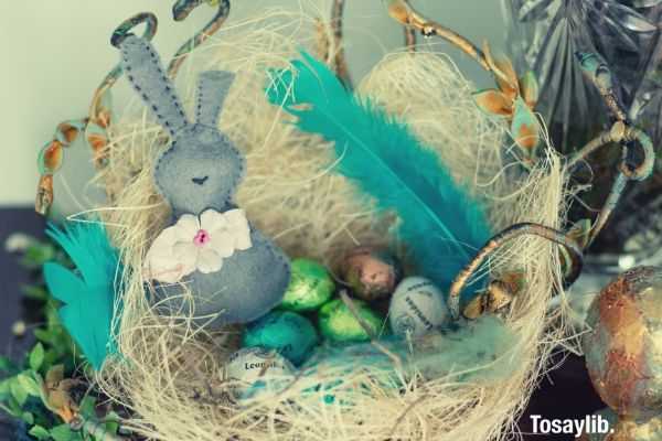 gray rabbit plush toy on brown nest photo with eggs