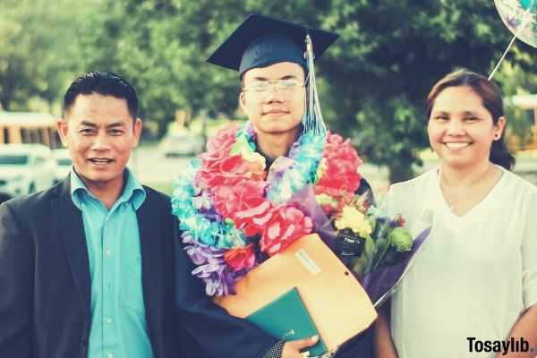 photo of a man wearing academic gown together with his parents