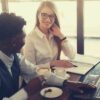 feature-cheerful-multiracial-coworkers-drinking-coffee-while-working-in-modern-workspace