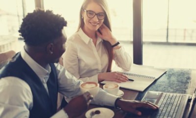 cheerful-multiracial-coworkers-drinking-coffee-while-working-in-modern-workspace