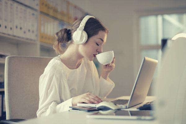 woman-in-white-dress-shirt-using-white-laptop-computer-and-drinking-on-her-white-cup