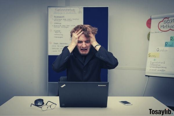 man wearing black holding his hair last minute meeting for work problem lenovo thinkpad laptop