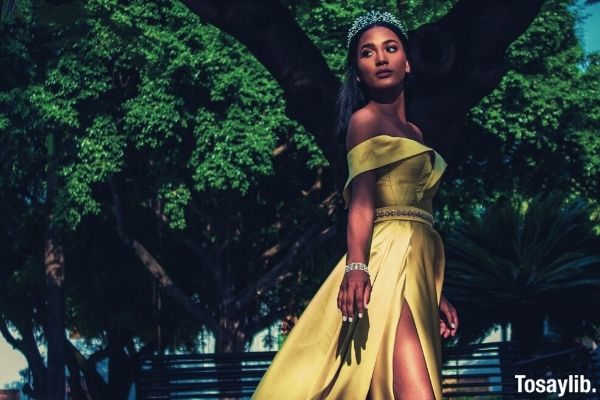 woman homecoming queen wearing yellow off shoulder slit dress with silver tiara