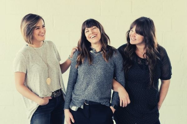 feature-three-women-laughing-how-to-say-you-are-welcome-smiling-looking-at-each-other