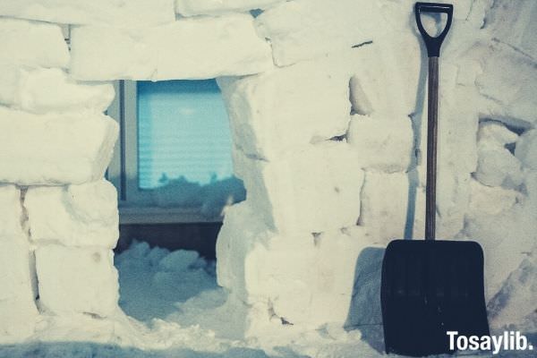 black shovel on white snow window and window blinds