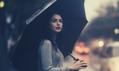 feature-words-to-describe-rain-woman-on-the-street-wearing-gray-sweater-holding-umbrella-car-lights