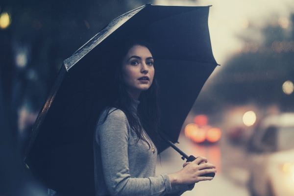 feature-words-to-describe-rain-woman-on-the-street-wearing-gray-sweater-holding-umbrella-car-lights