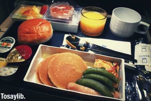 delicious in flight meal served orange juice pancake bread