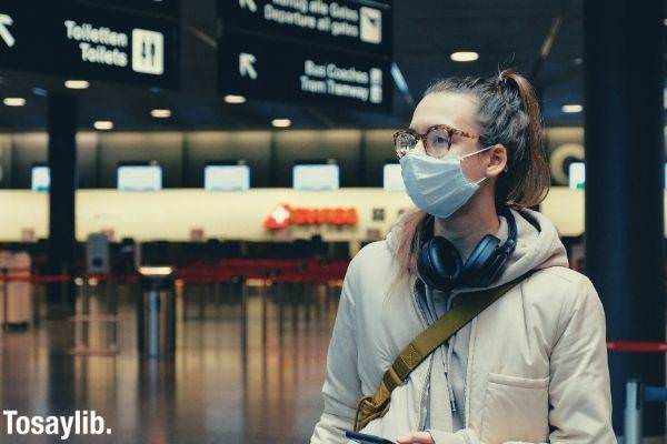 woman wearing facemask with headphones hanging on neck