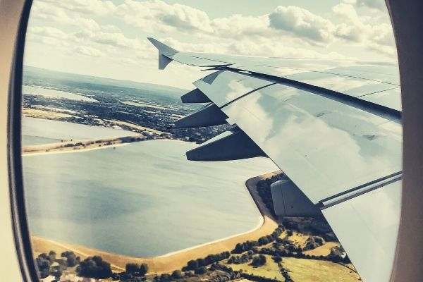 airplane window seat view flight sky and field