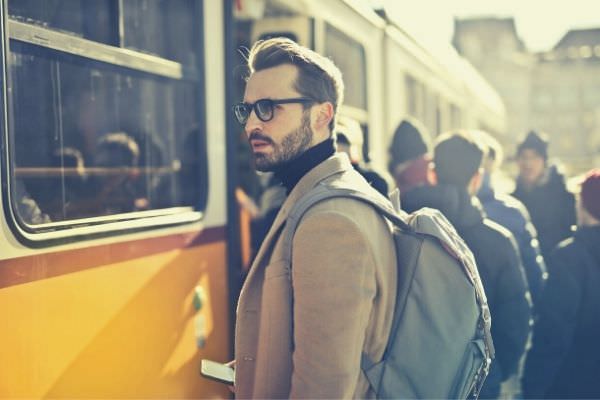 man-wearing-formal-with-backpack-holding-smartphone-standing-on-the-station-ways-to-say-take-care