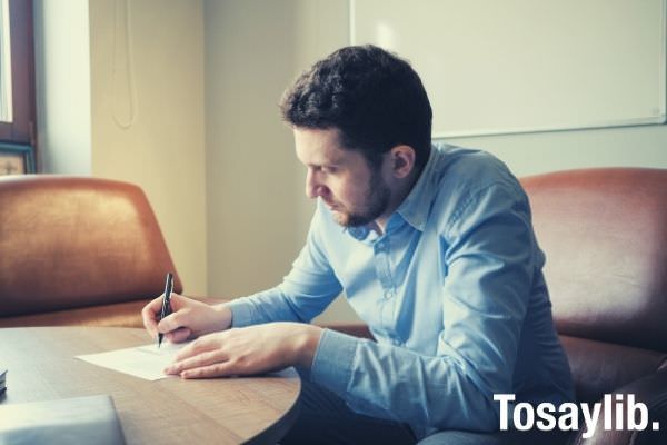 businessman working on project sitting at office desk wearing blue formal polo