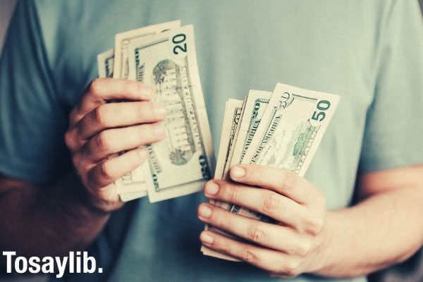 cropped photo of a man counting dollar banknotes