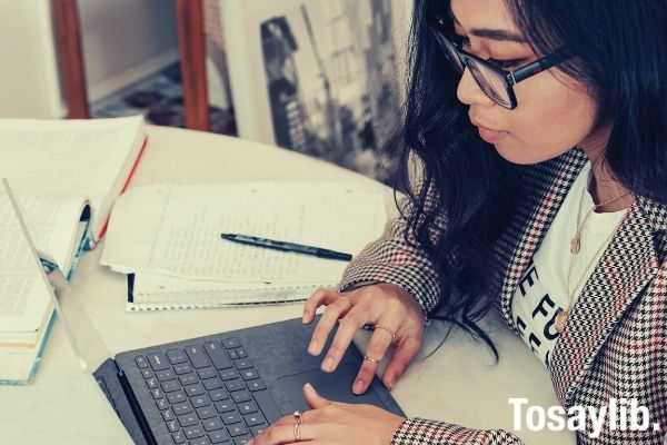 woman in red and white plaid using laptop wearing eyeglasses