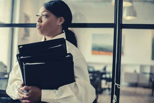 serious black woman carrying documents in office ask for time to consider job offer
